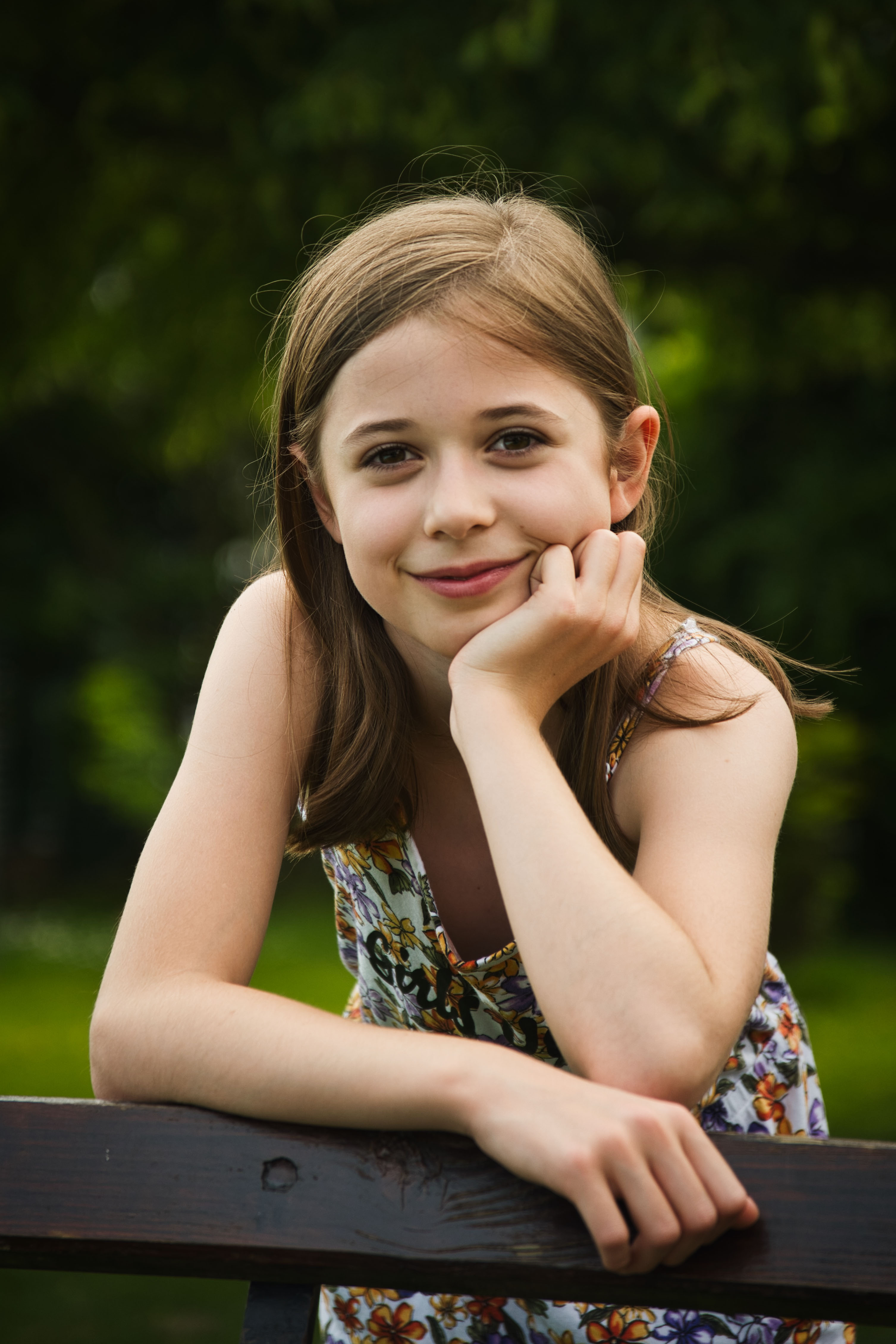 Porträt eines lächelnden Mädchens in einem Sommerkleid im Garten