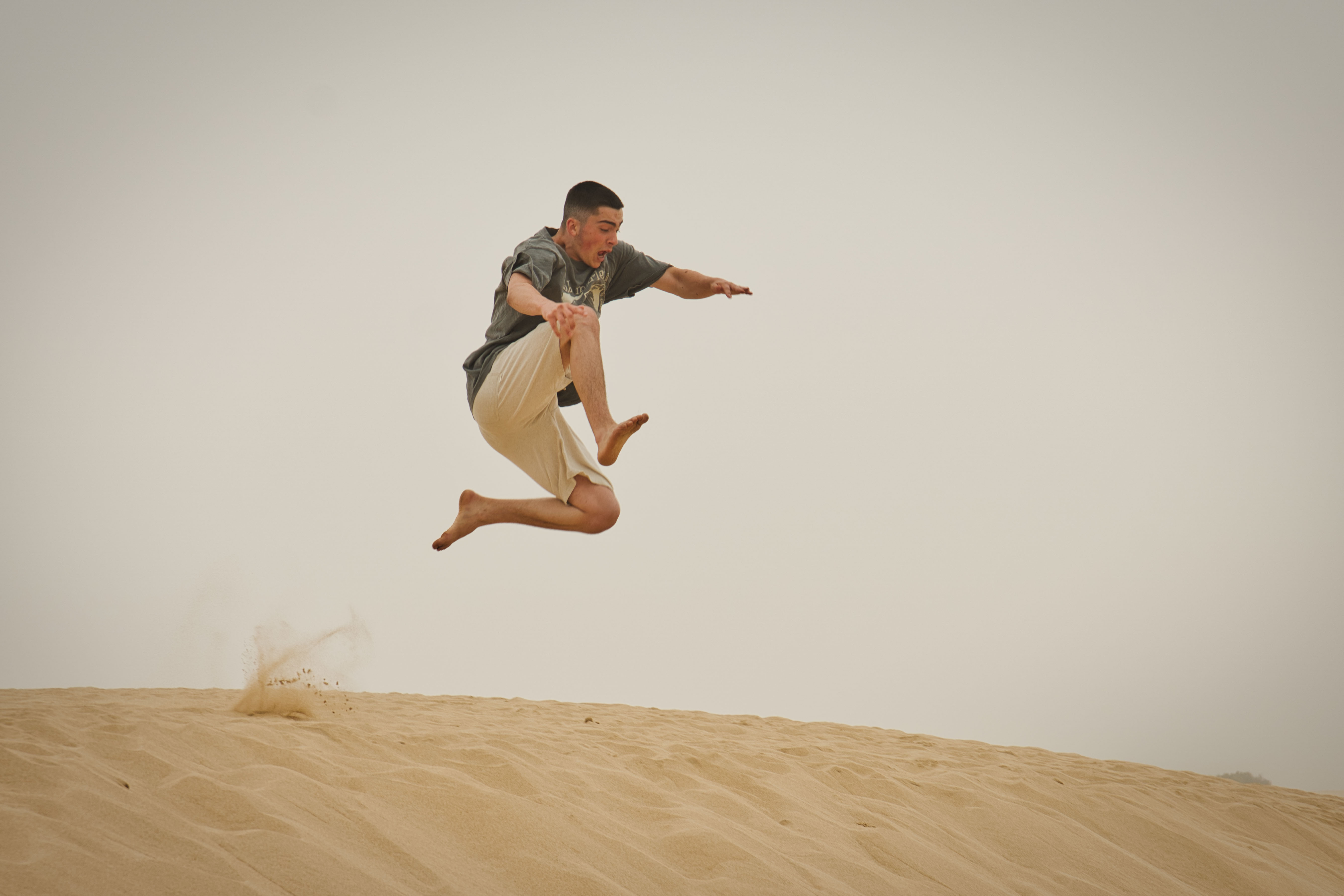 Lorenz Dietrich springt von einer Düne an einem Strand in Portugal