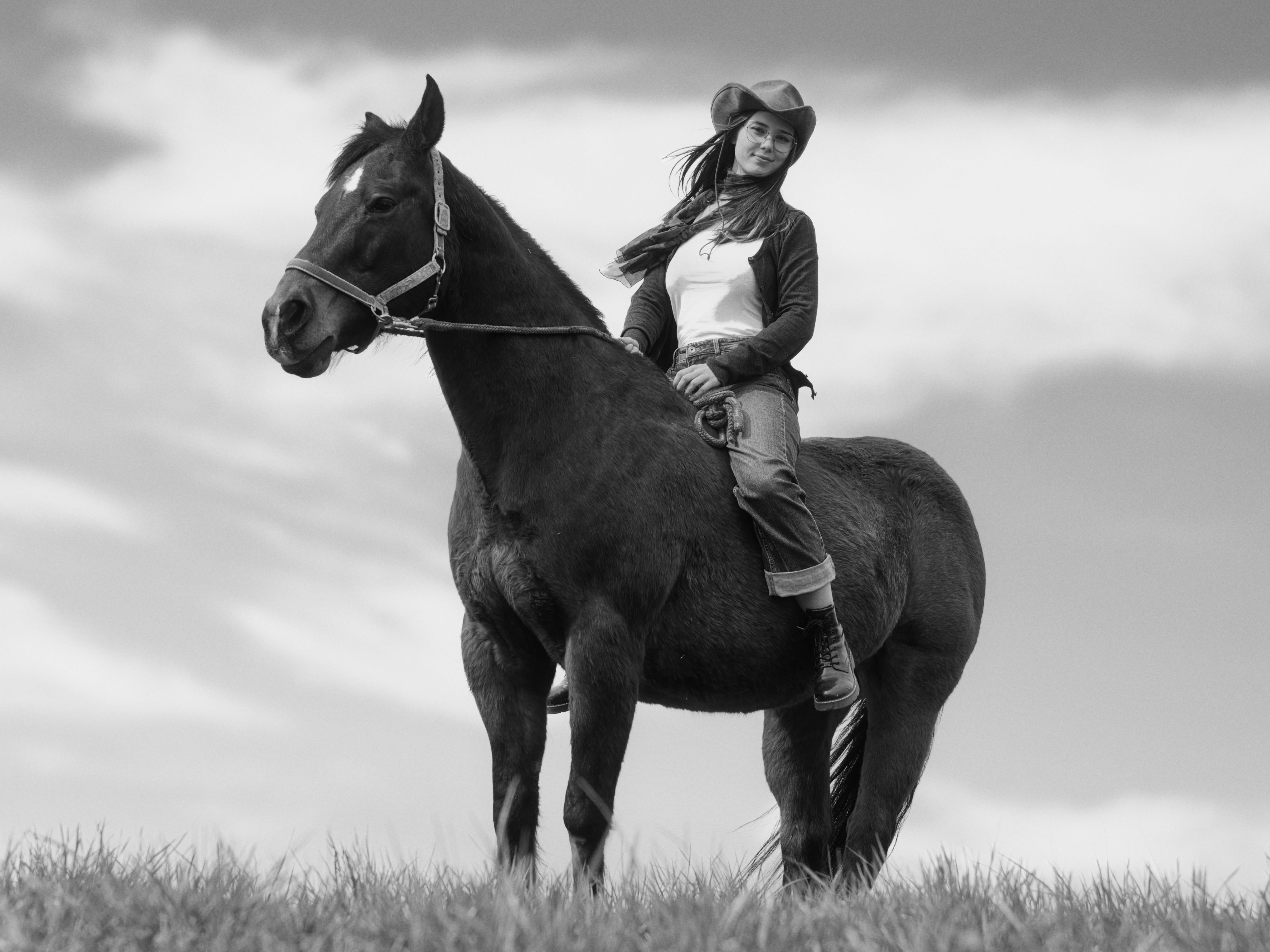 vintage-Style Porträt von Lena Lorenz auf einem schwarzen Pferd, schwarzweiß Foto